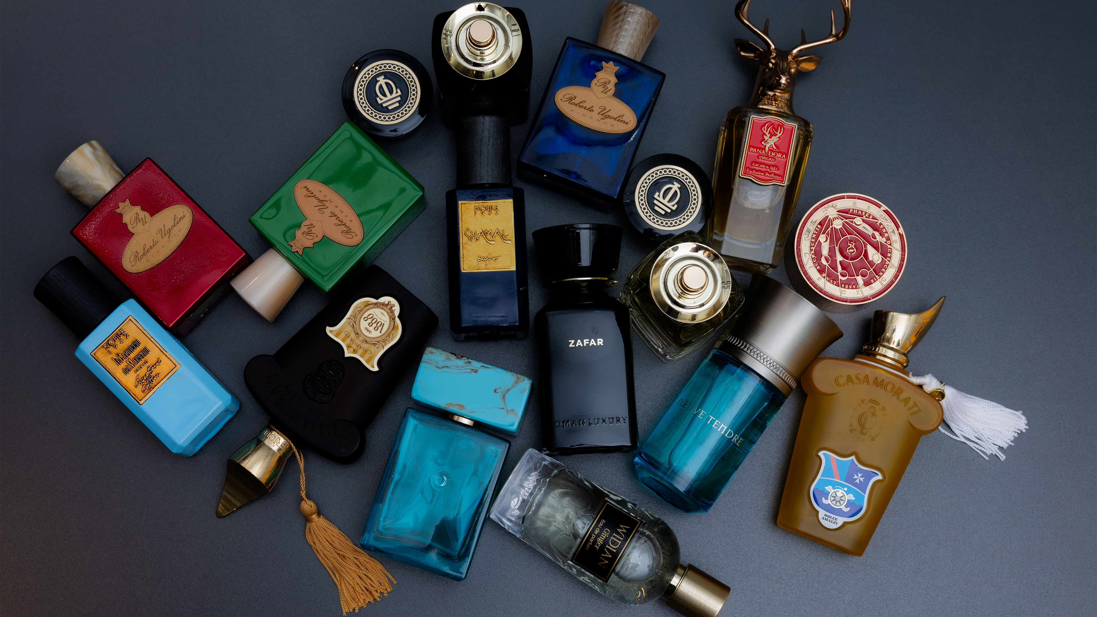 viele Glasflaschen liegen auf einem dunkelgrauen Untergrund