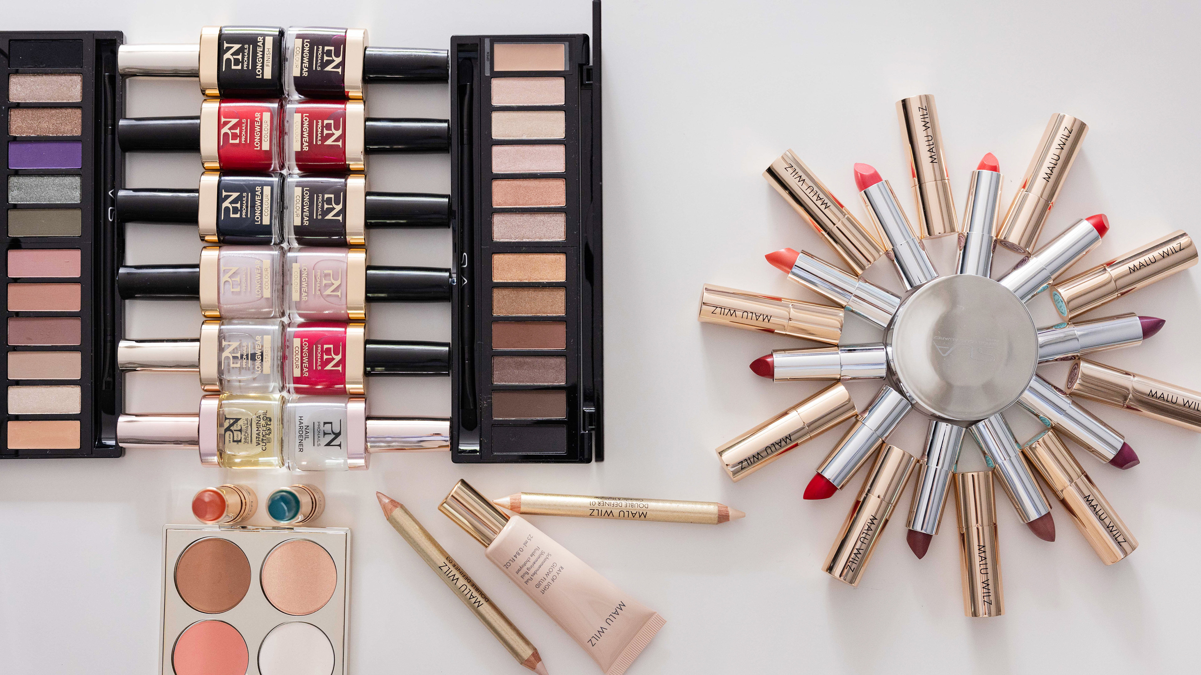 verschiedene Kosmetikartikel liegen auf weißem Untergrund