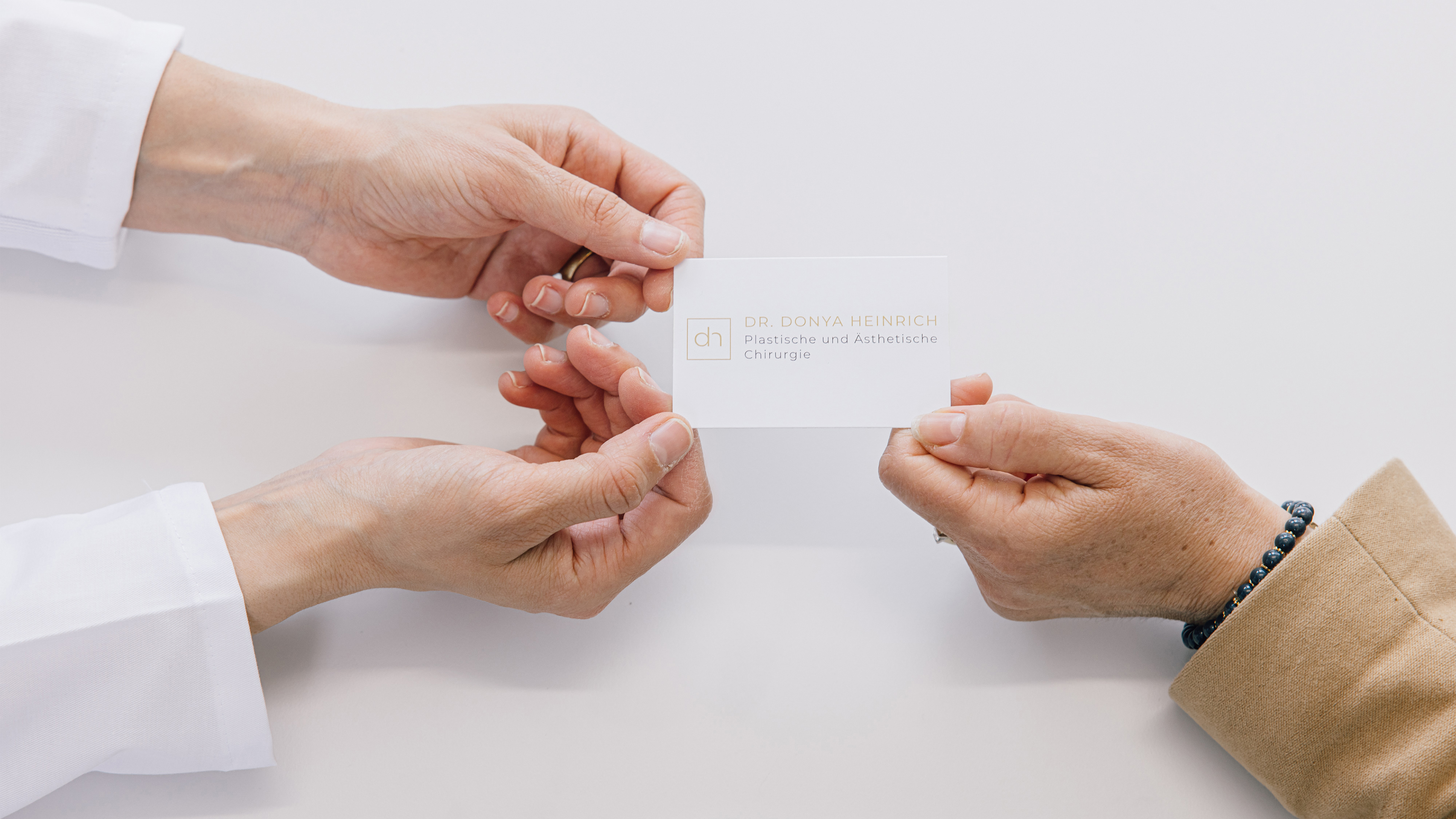 H&auml;nde, die eine Visitenkarte halten