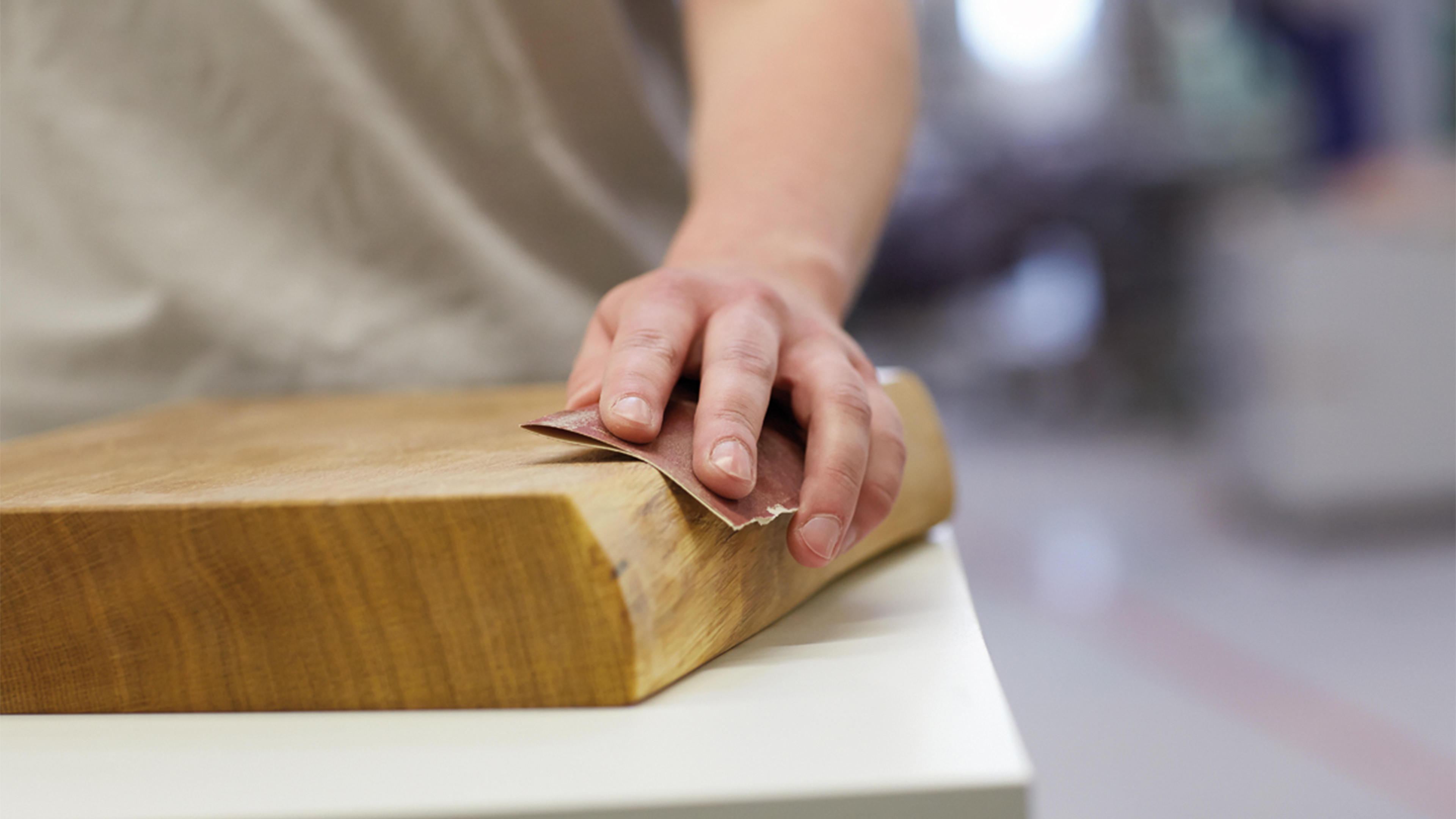 Holzst&uuml;ck, das mit Schleifpapier geschliffen wird