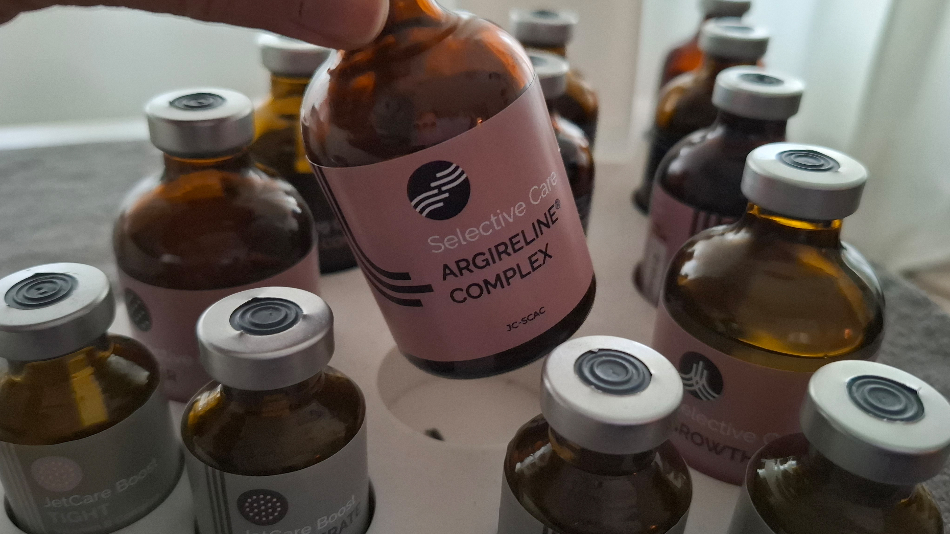 verschiedene Fläschchen, eins wird angehoben