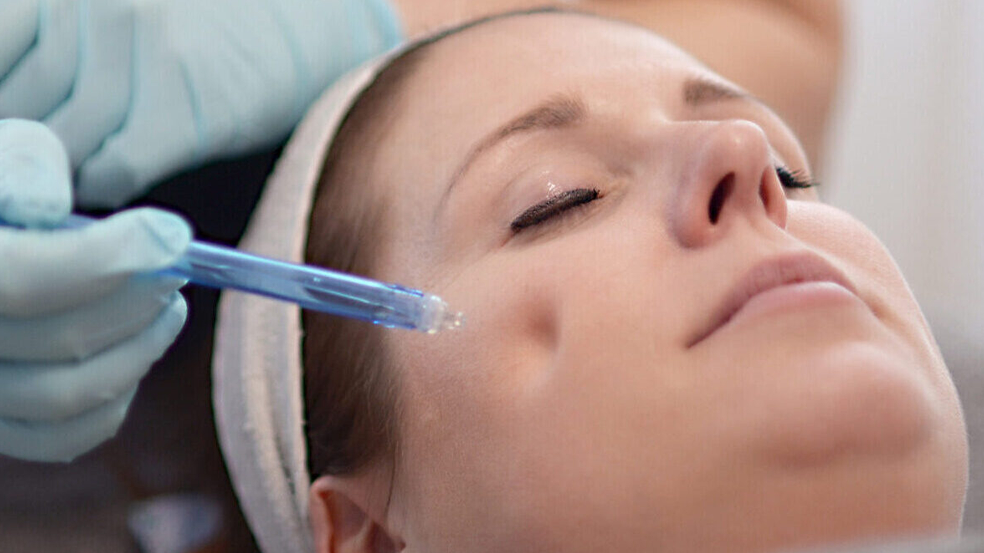 Ein Frauenkopf mit Augen zu, bekommt eine Gesichtsbehandlung