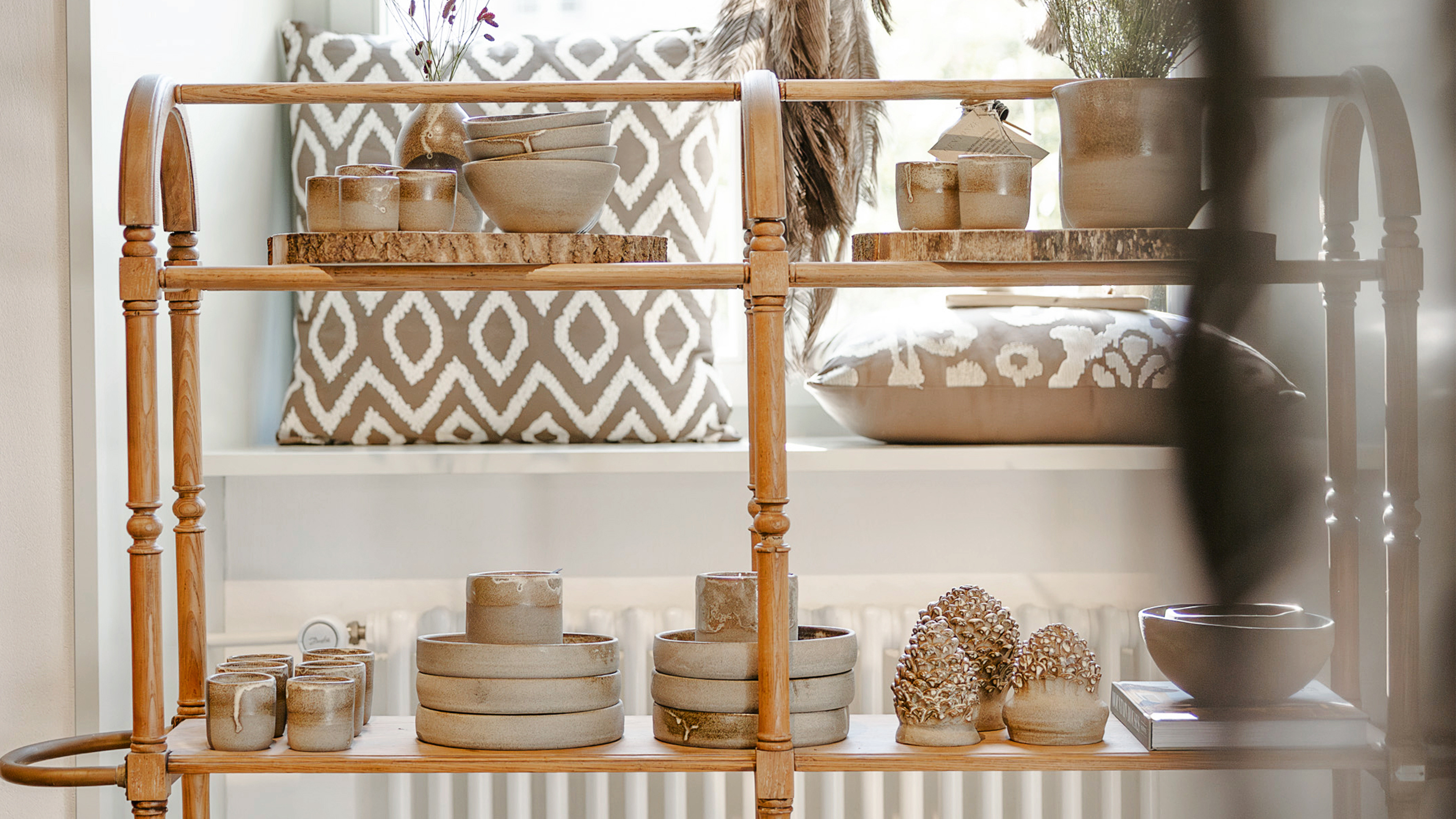 ein Holzregal mit Schalen, Tassen und Tellern drauf
