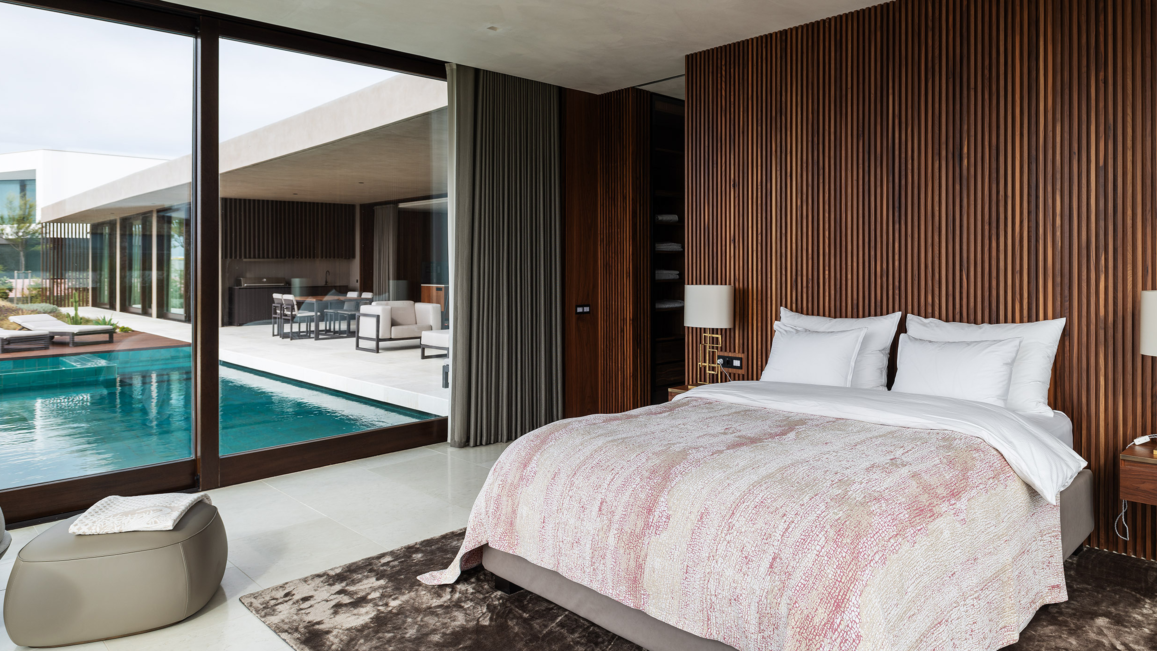 Schlafzimmer mit Fenster nach draußen, wo ein Pool ist