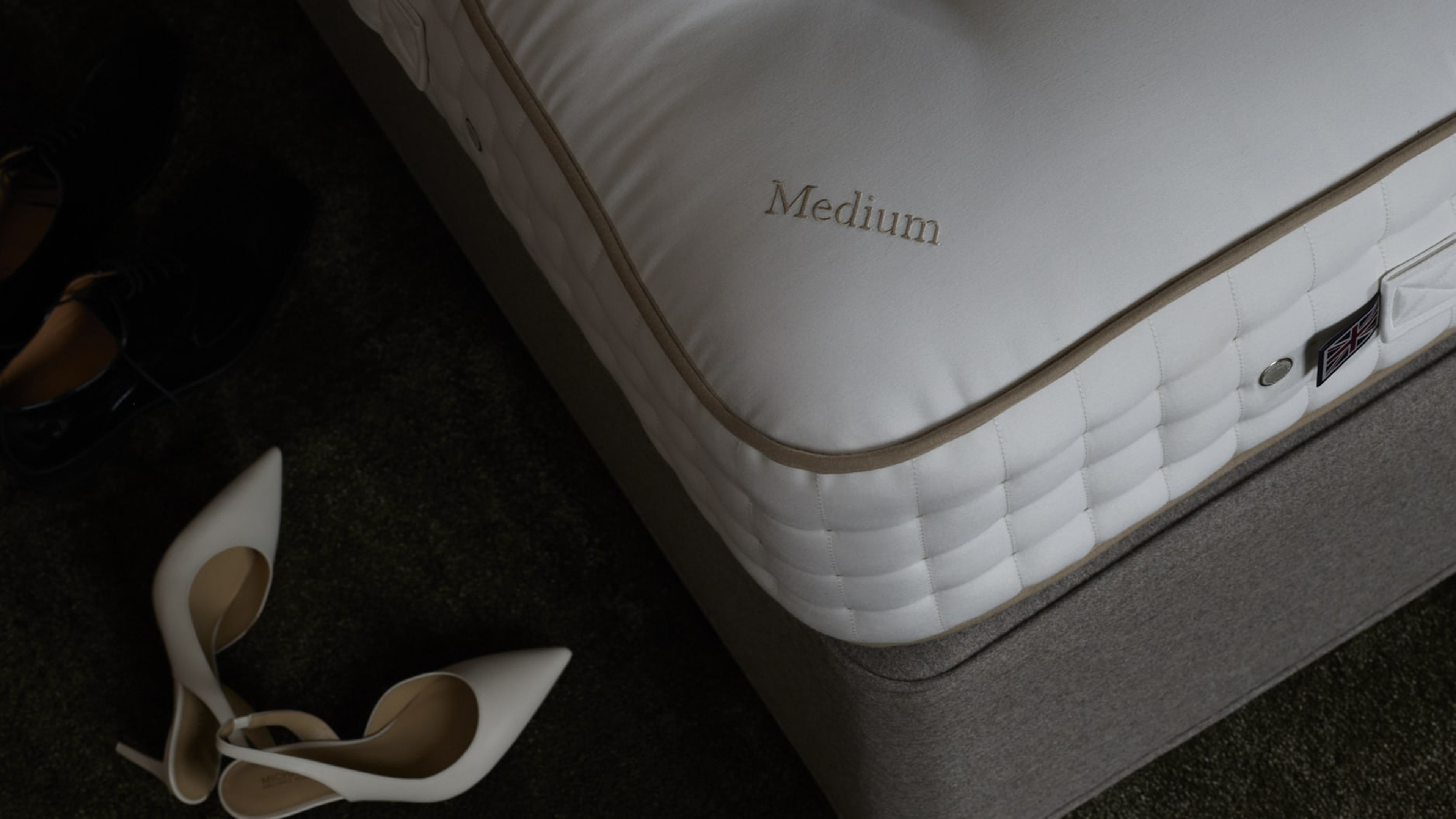 Eine Matratze und auf dem Boden sieht man Damenschuhe