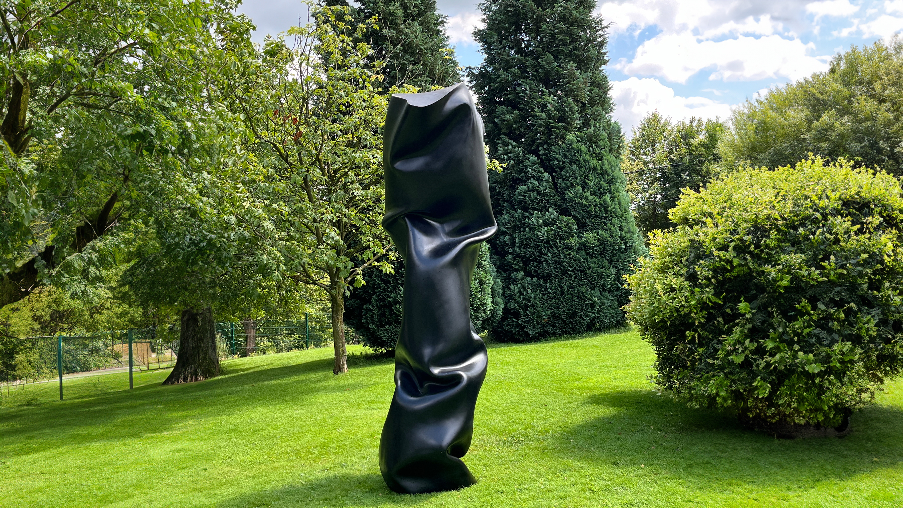 Gro&szlig;e schwarze moderne Skulptur in der Natur 