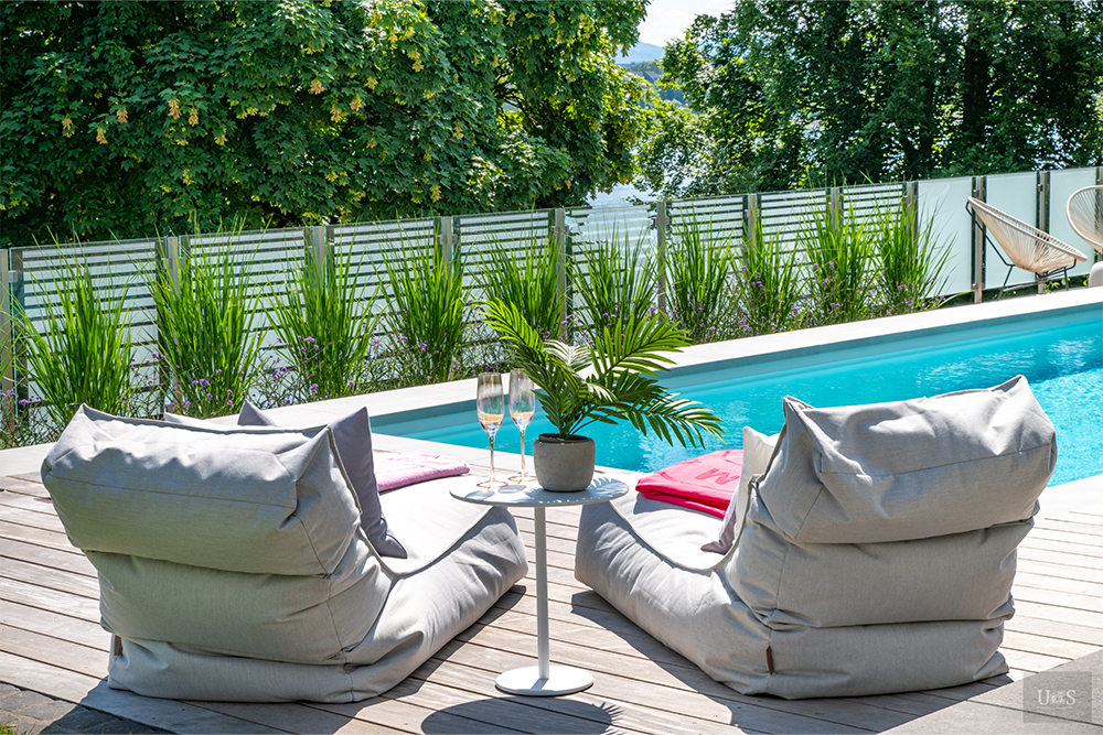 Sitzkissen am Pool mit Sektgläsern