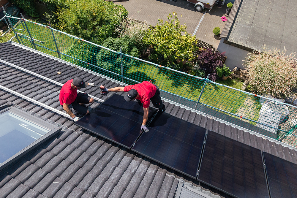 Zwei Männer, die Photovoltaik anbringen