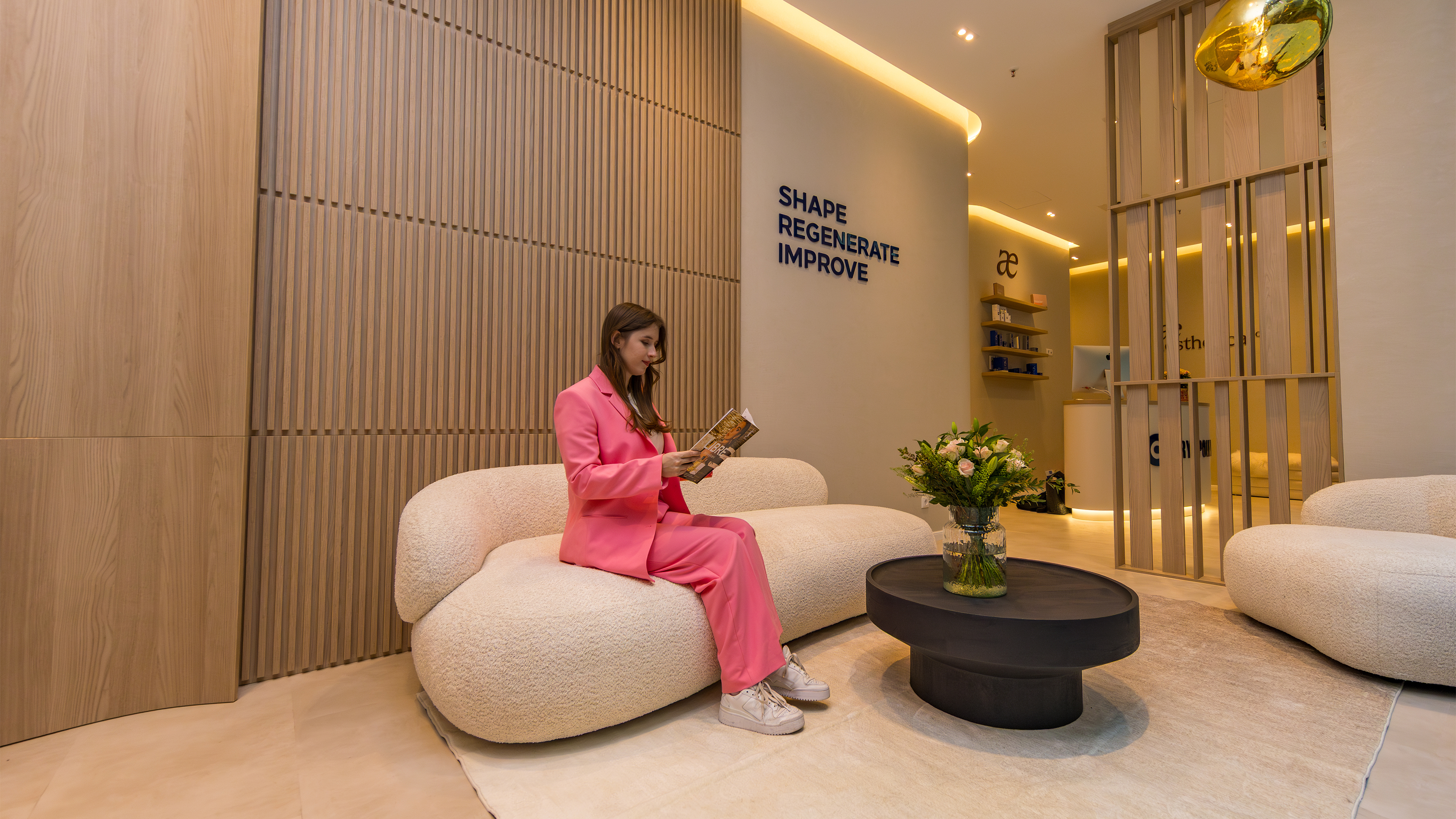 Dame mit pinkem Anzug sitzt im Wartebereich