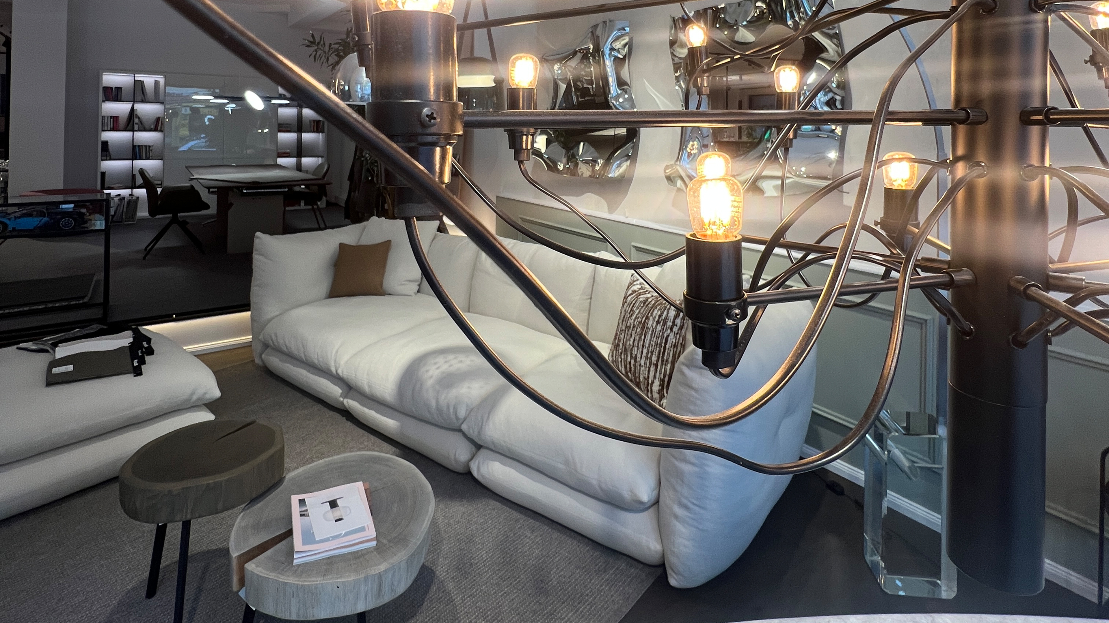 Exklusive Lichtgestaltung und modernes Wohnzimmer-Ensemble im Albert Grimm Studio G&ouml;ppingen &ndash; Kuratiertes Interior Design mit Designer-Leuchten und hochwertigem Polstersofa.