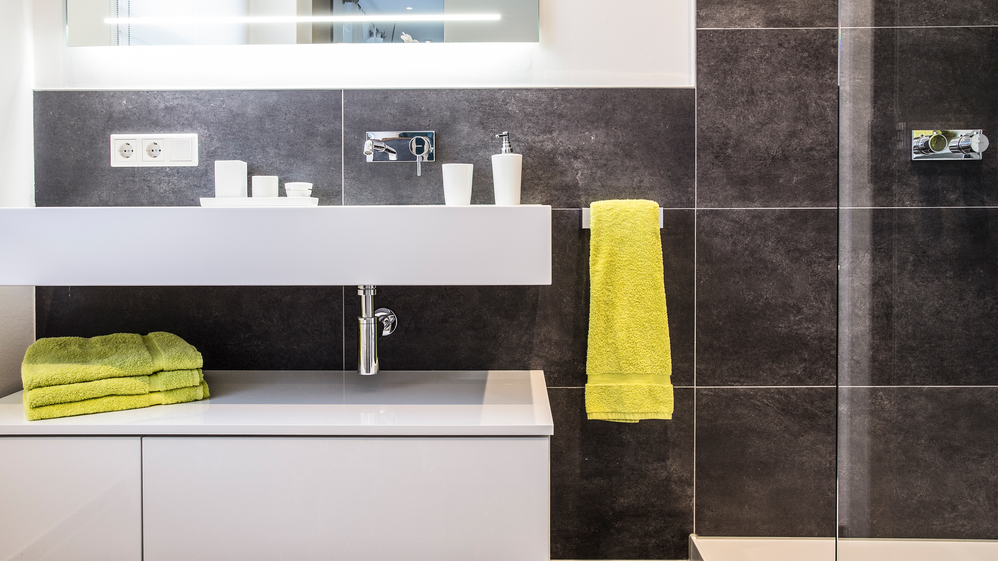 Modernes Badezimmer mit wandmontiertem Waschbecken, Unterschrank und bodengleicher Dusche &ndash; hochwertige Badsanierung von bagno Badstudio in Mainz