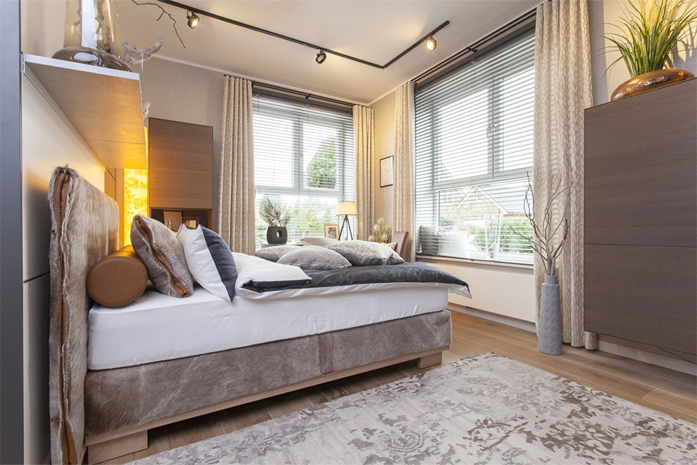 Boxspringbett mit hellbraunem Samt und grau weißer Bettwäsche