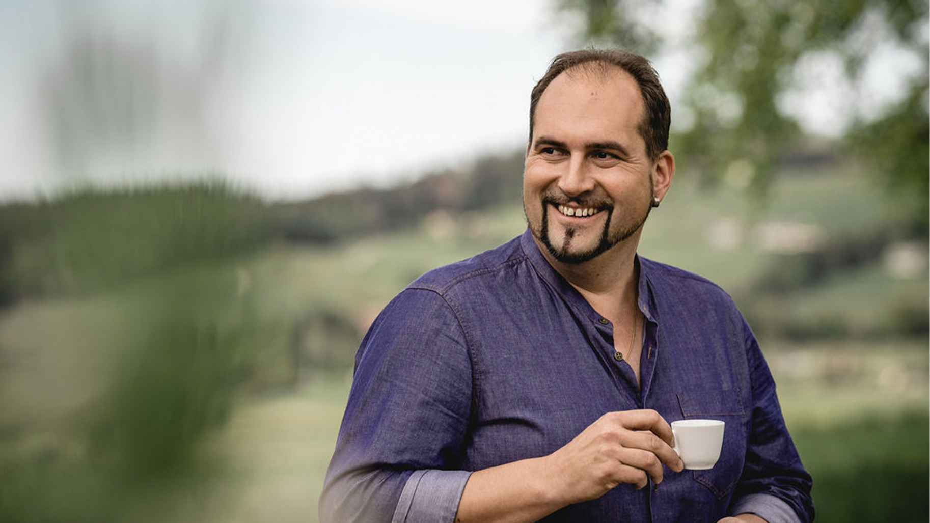 Willy Zemp genießt einen Espresso vor einer Schweizer Landschaft