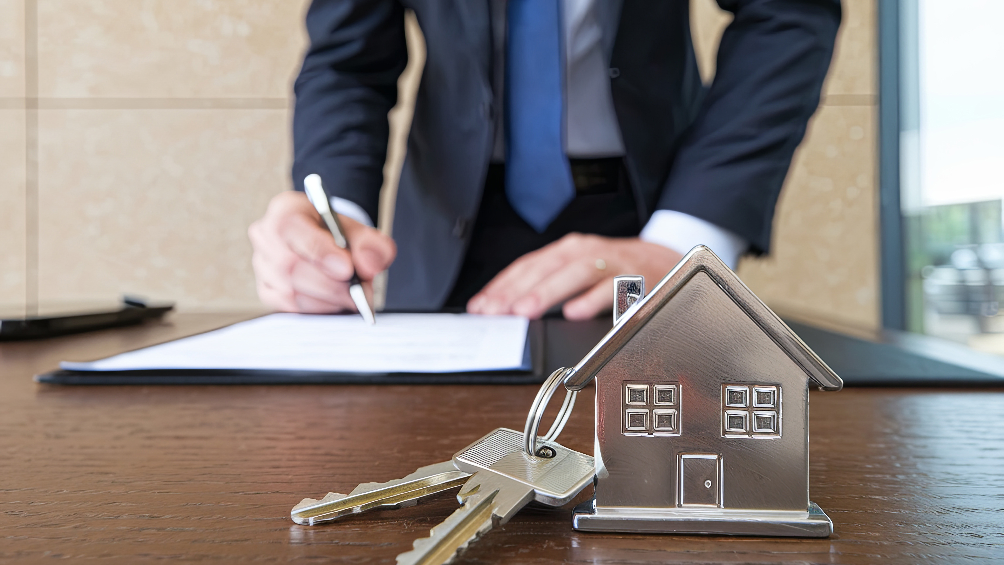 Vertragsunterzeichnung beim Notar und im Vordergrund die Hausschl&uuml;ssel