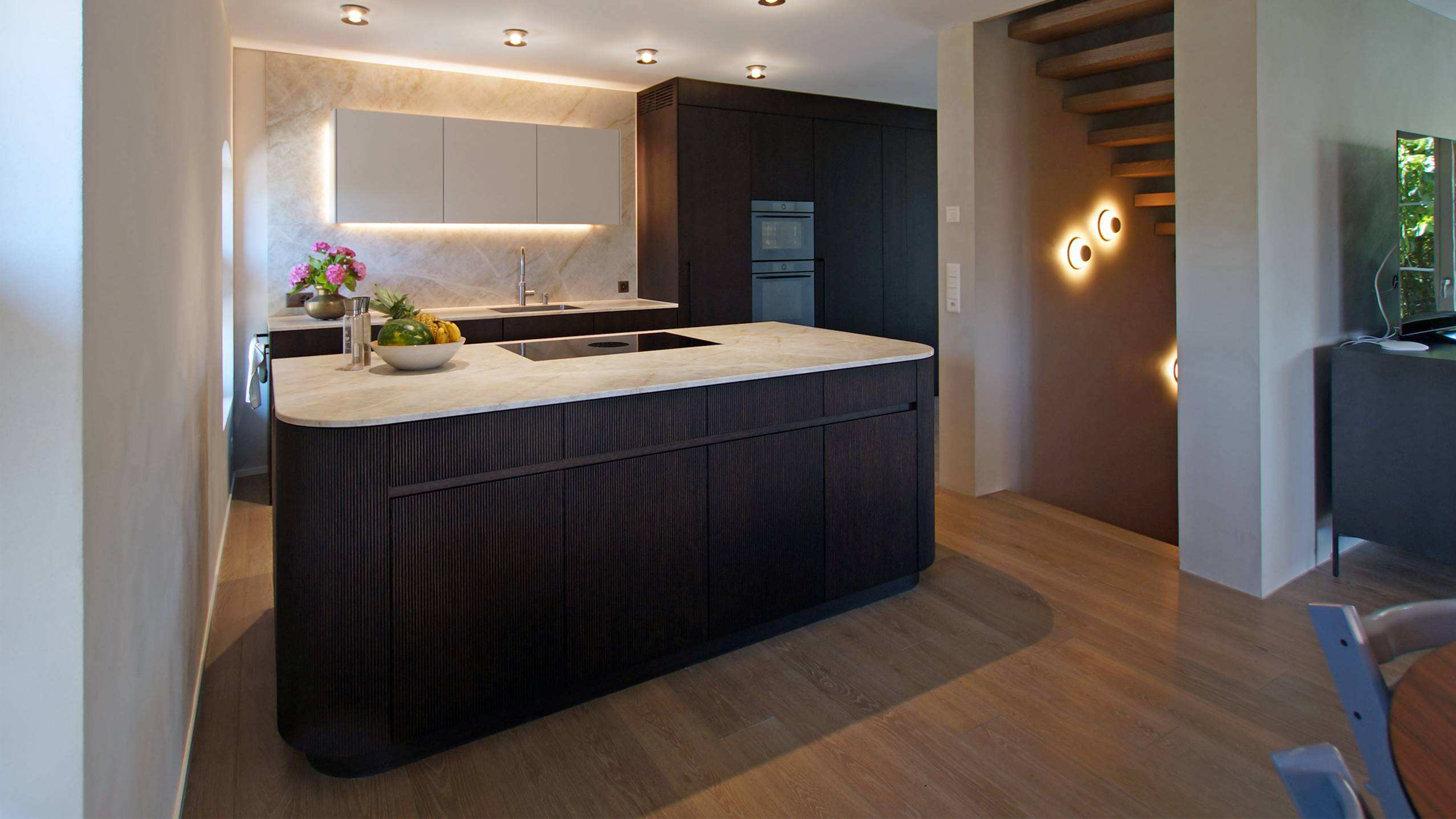 Moderne Küche aus dunklem Holz und heller Granitplatte auf der Kücheninsel