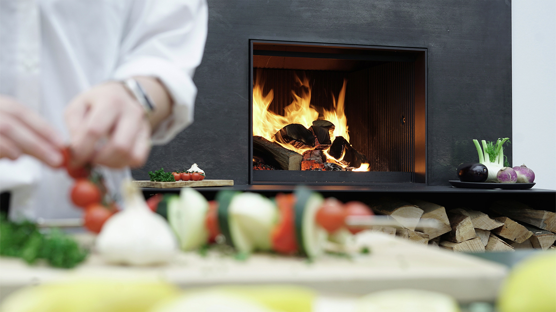 Brennender Holzkamin in der Küche während der Zubereitung frischer Speisen