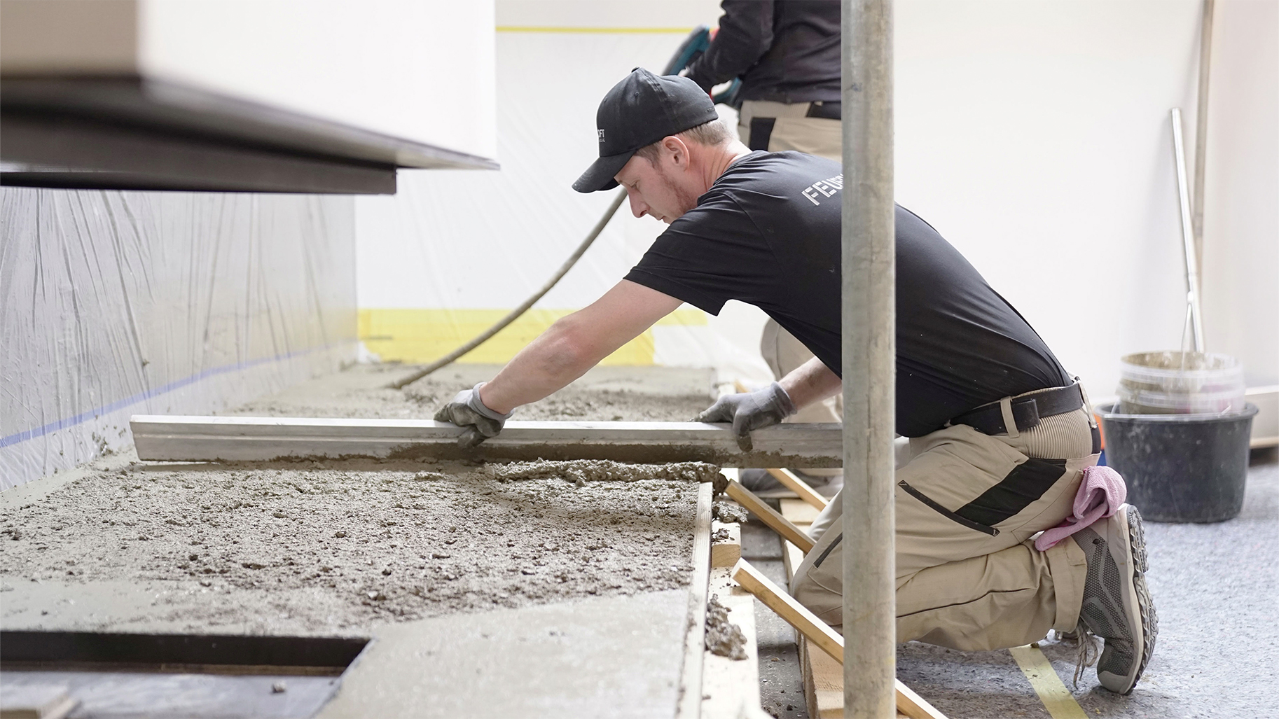 Ofenbauer bei der handwerklichen Ausführung einer maßgefertigten Kaminanlage aus Beton
