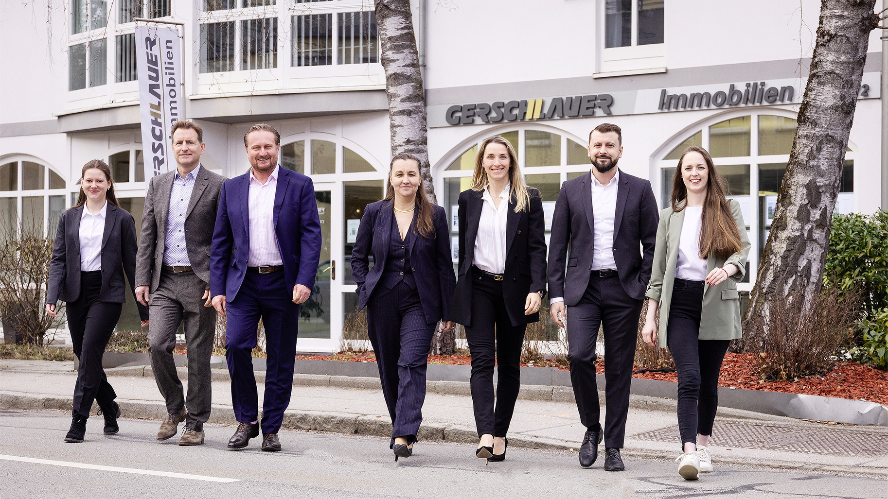Das Team von Gerschlauer Immobilien in München rund um Geschäftsführerin Manuela Gerschlauer-Wüstenhagen vor dem Büro.