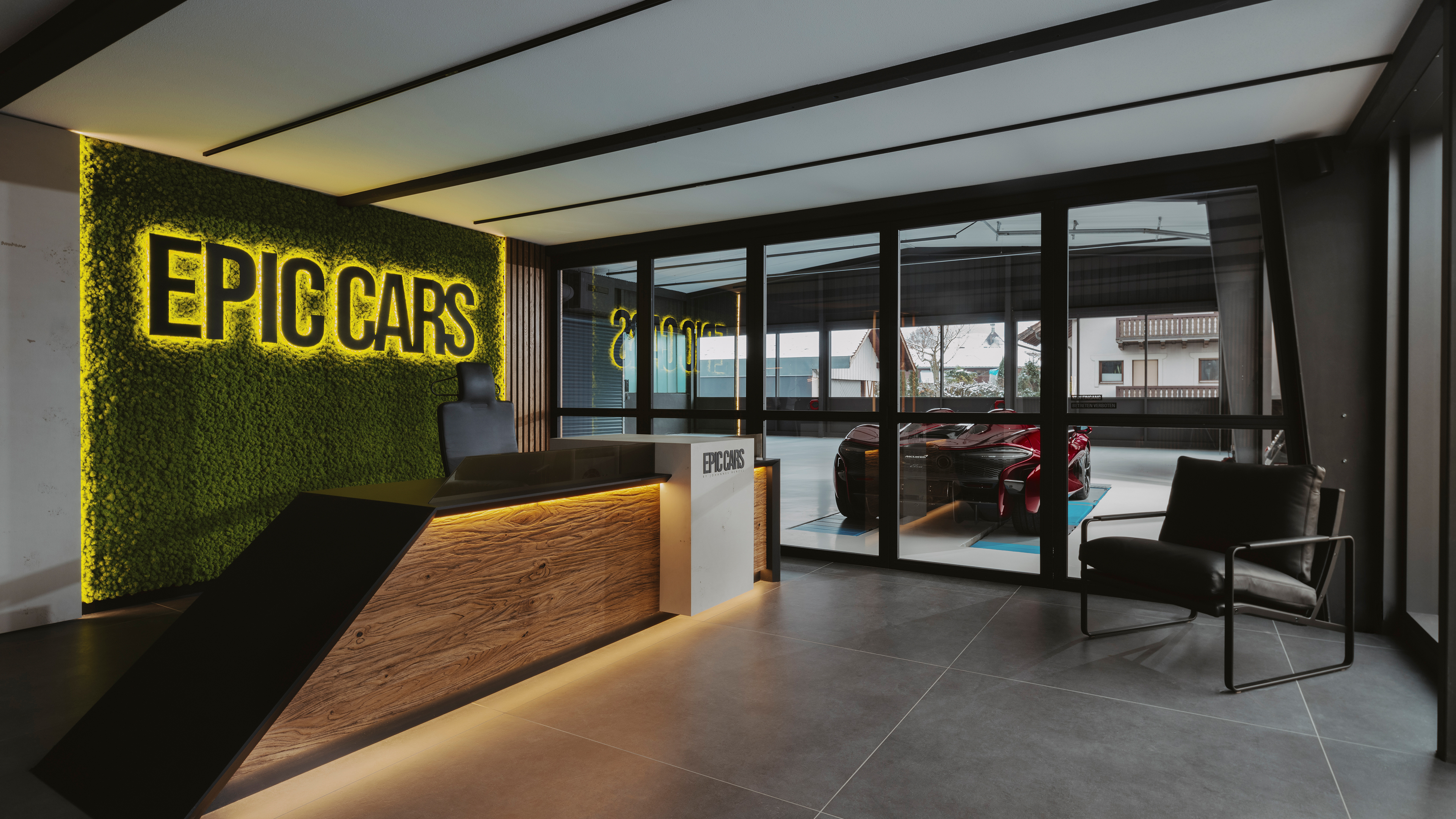 Showroom für Epic Cars mit Holztheke und grüner Naturwand von Grabner Design GmbH
