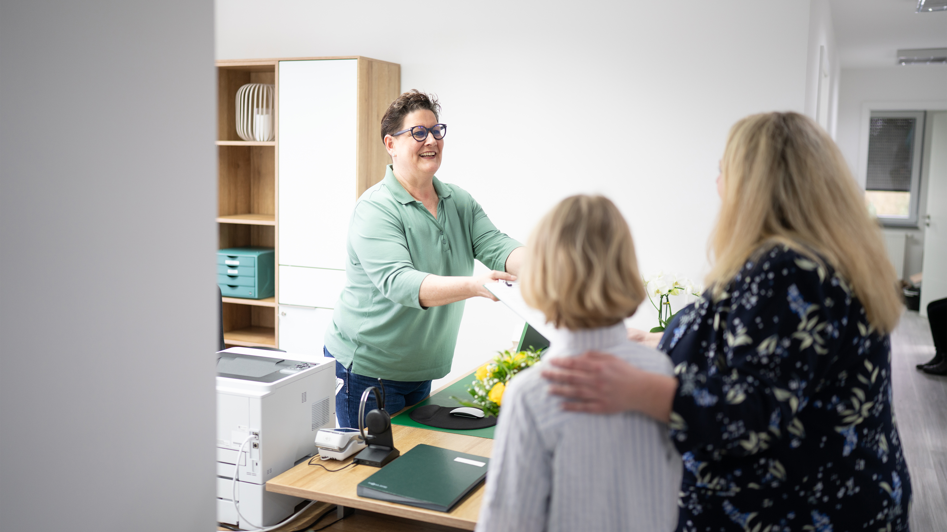 Mutter und Kind an der Anmeldung mit einem Anamnesebogen