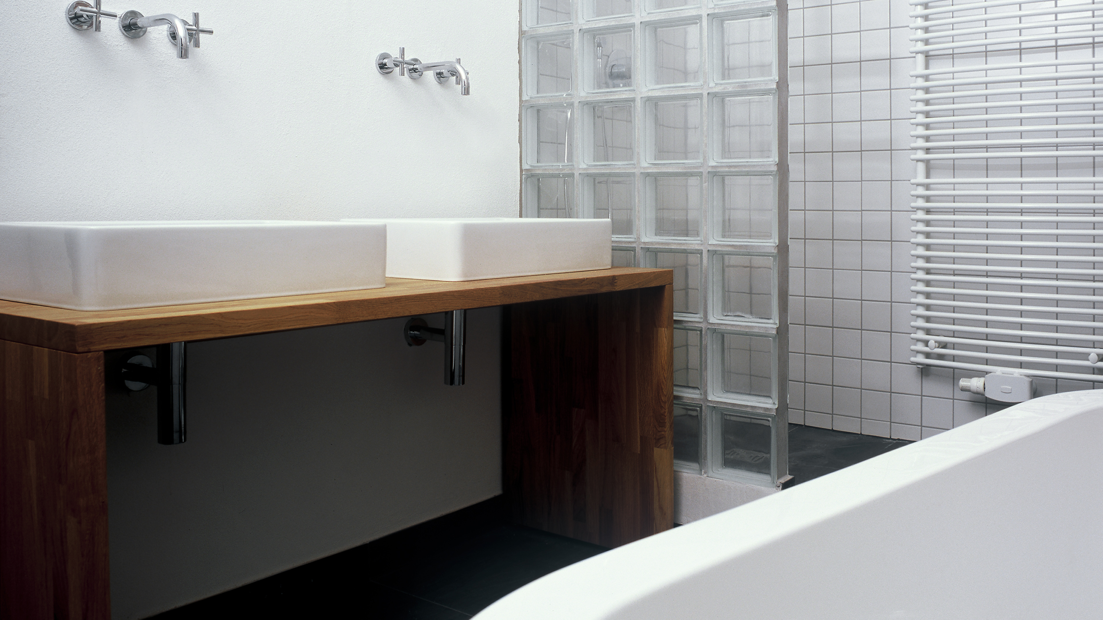 Modernes Badezimmer mit zwei Waschbecken und Duschwand aus Glasbausteinen