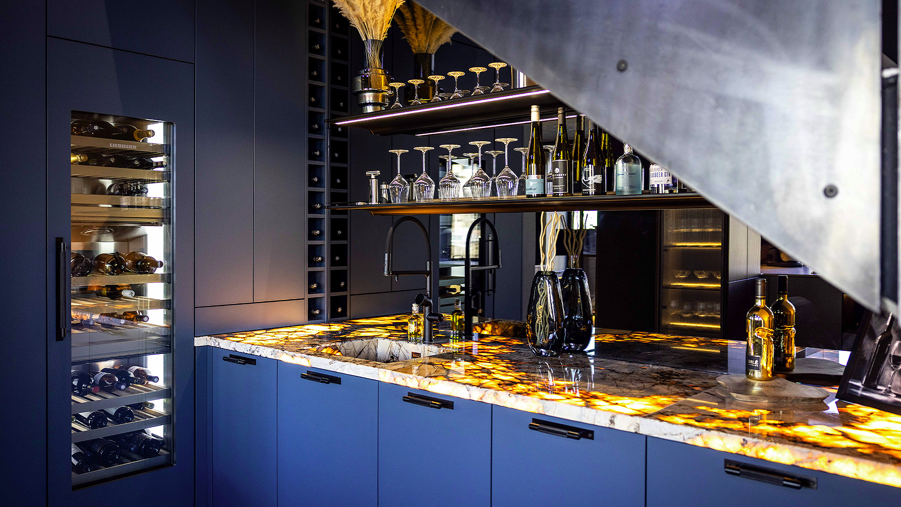 Exklusive Designküche mit Barbereich, Weinkühlschrank und beleuchteter Natursteinplatte von Kitchen Crew Hamburg