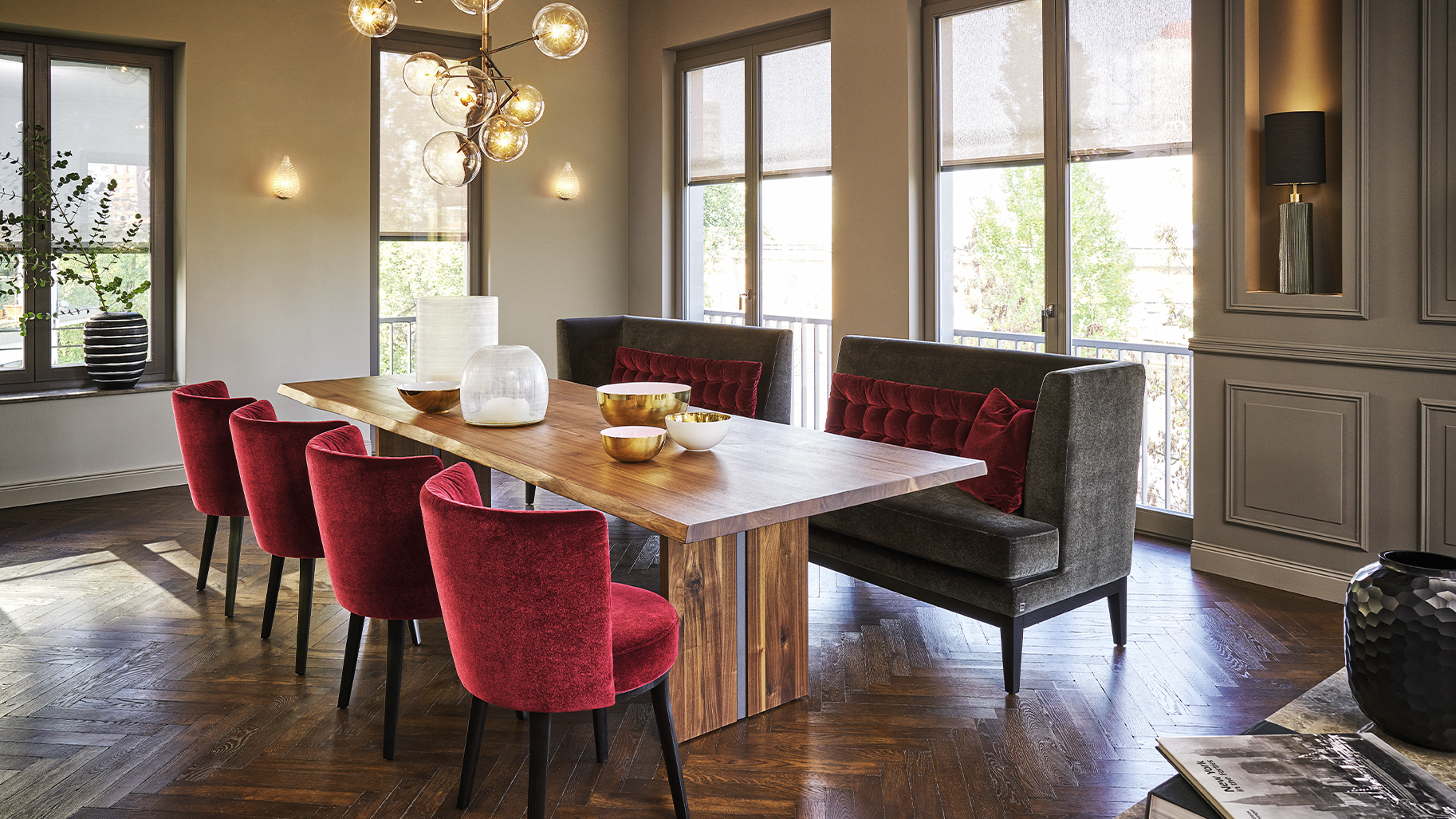 Elegantes Esszimmer mit Holztisch, roten Samtst&uuml;hlen und Designerleuchte &ndash; hochwertiges Interior Design mit warmem Wohnambiente