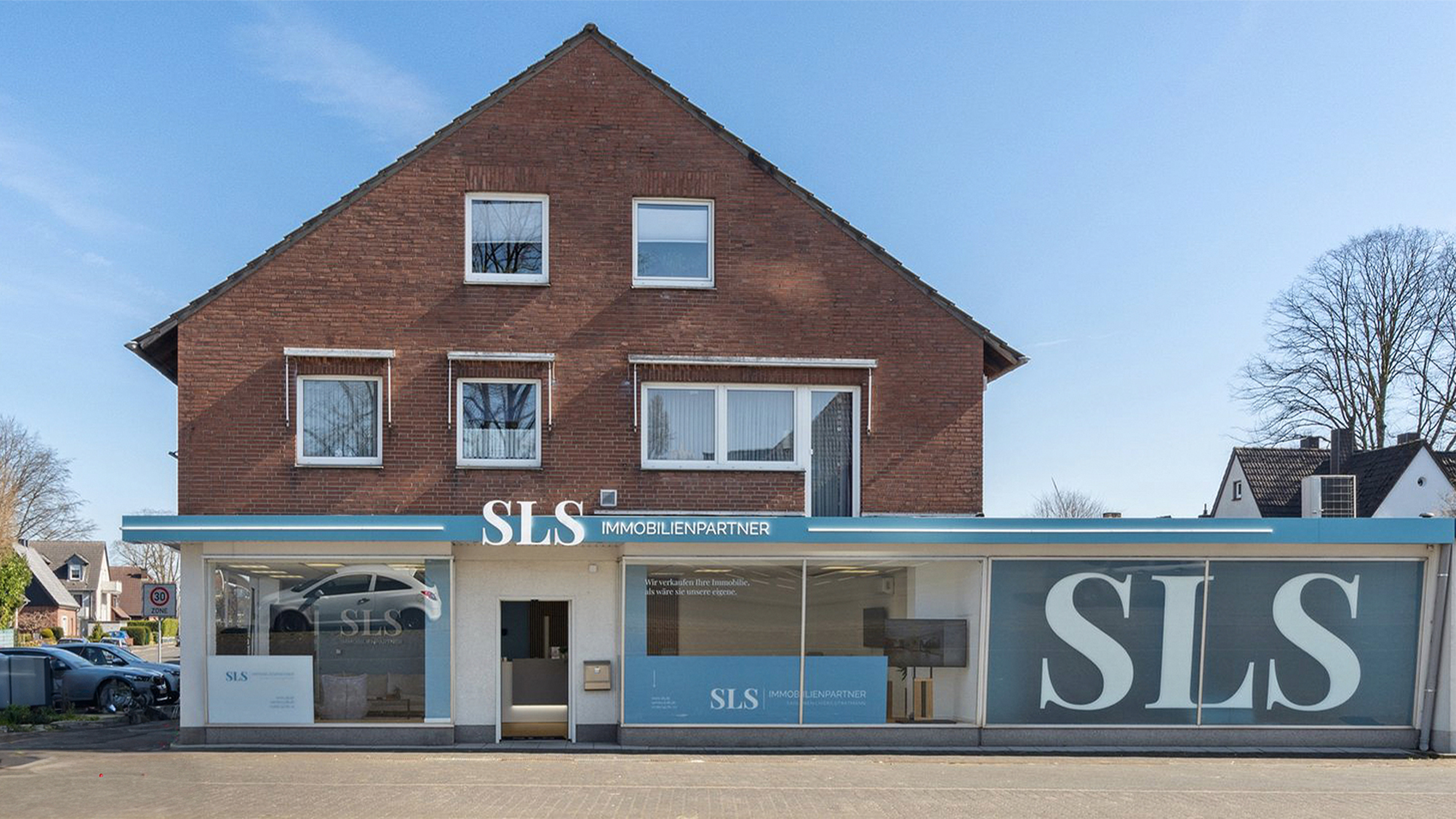 Außenansicht des Büros von SLS Immobilienpartner in Dorsten mit großflächiger Fensterbeschriftung.