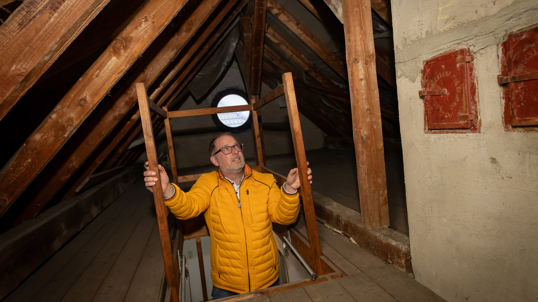 Wunschmakler Stefan Schulte auf der Treppe zum Dachboden einer exklusiven Immobilie, professionelle Begutachtung.