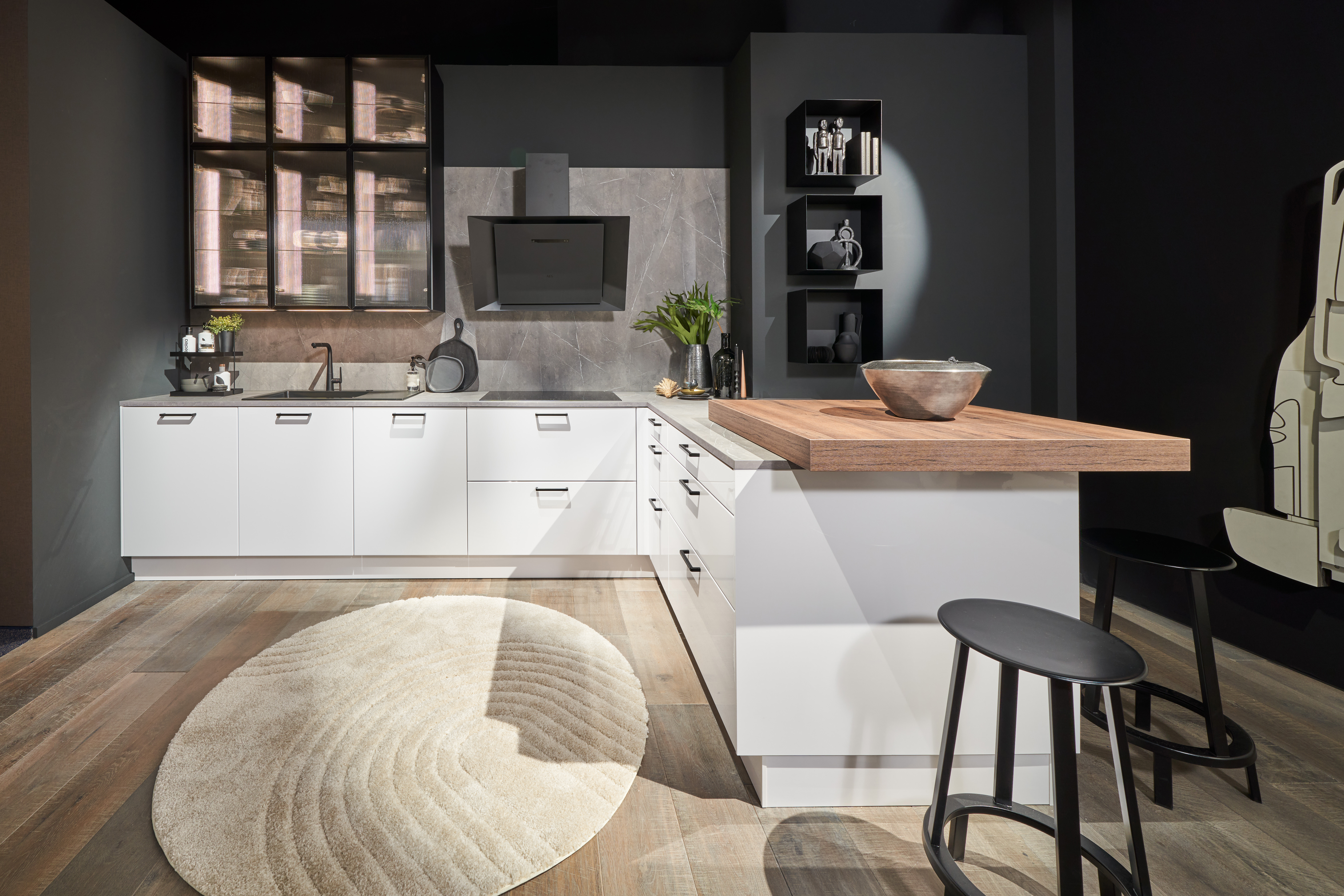 Hochwertige Einbauküche von di Vinci Kitchen in Jestetten mit weißen Fronten, Holzkohle-Wänden und einer Kochinsel.
