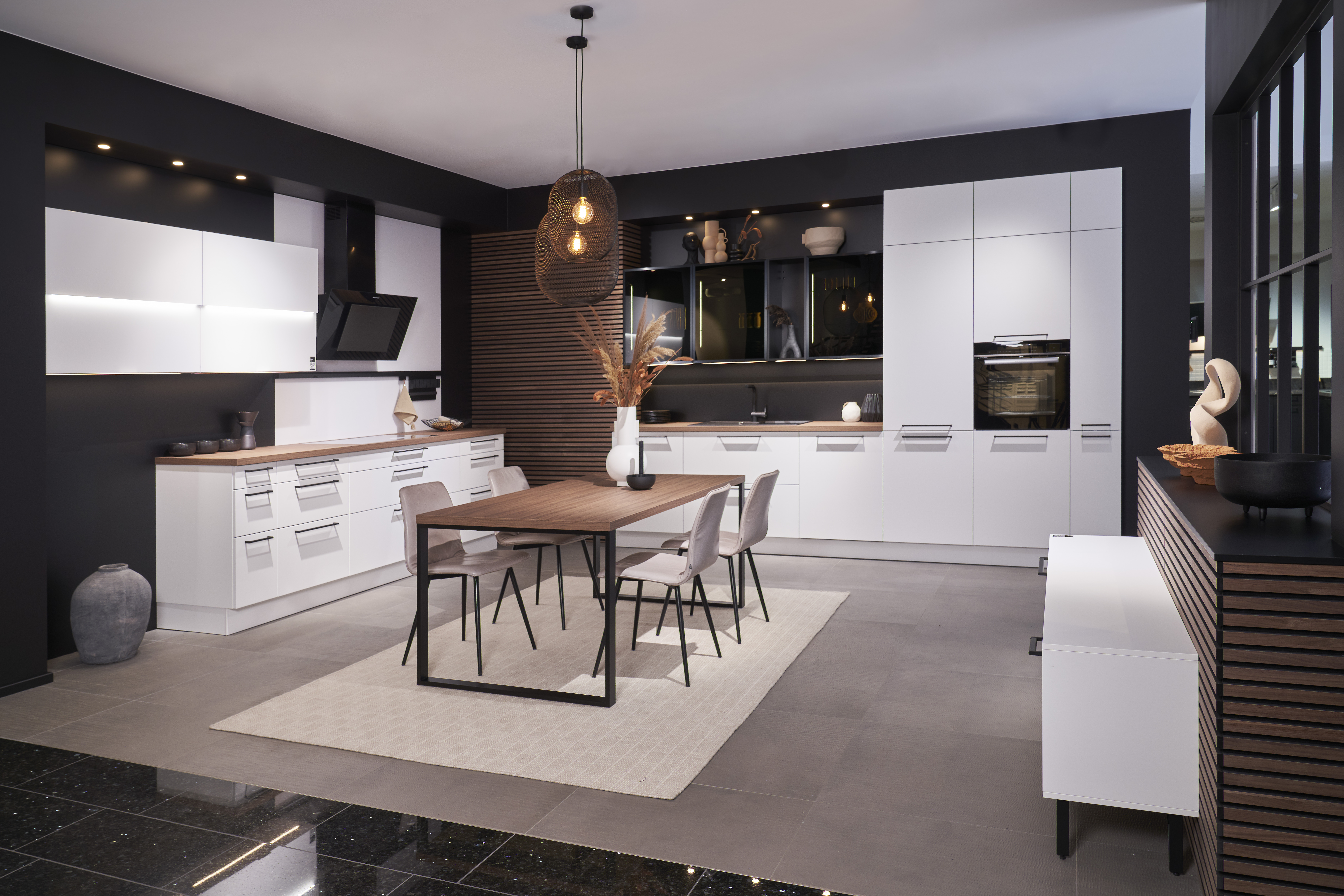 Großzügige Schreinerküche nach Maß von di Vinci Kitchen in Jestetten mit weißen Fronten und integriertem Esstisch.