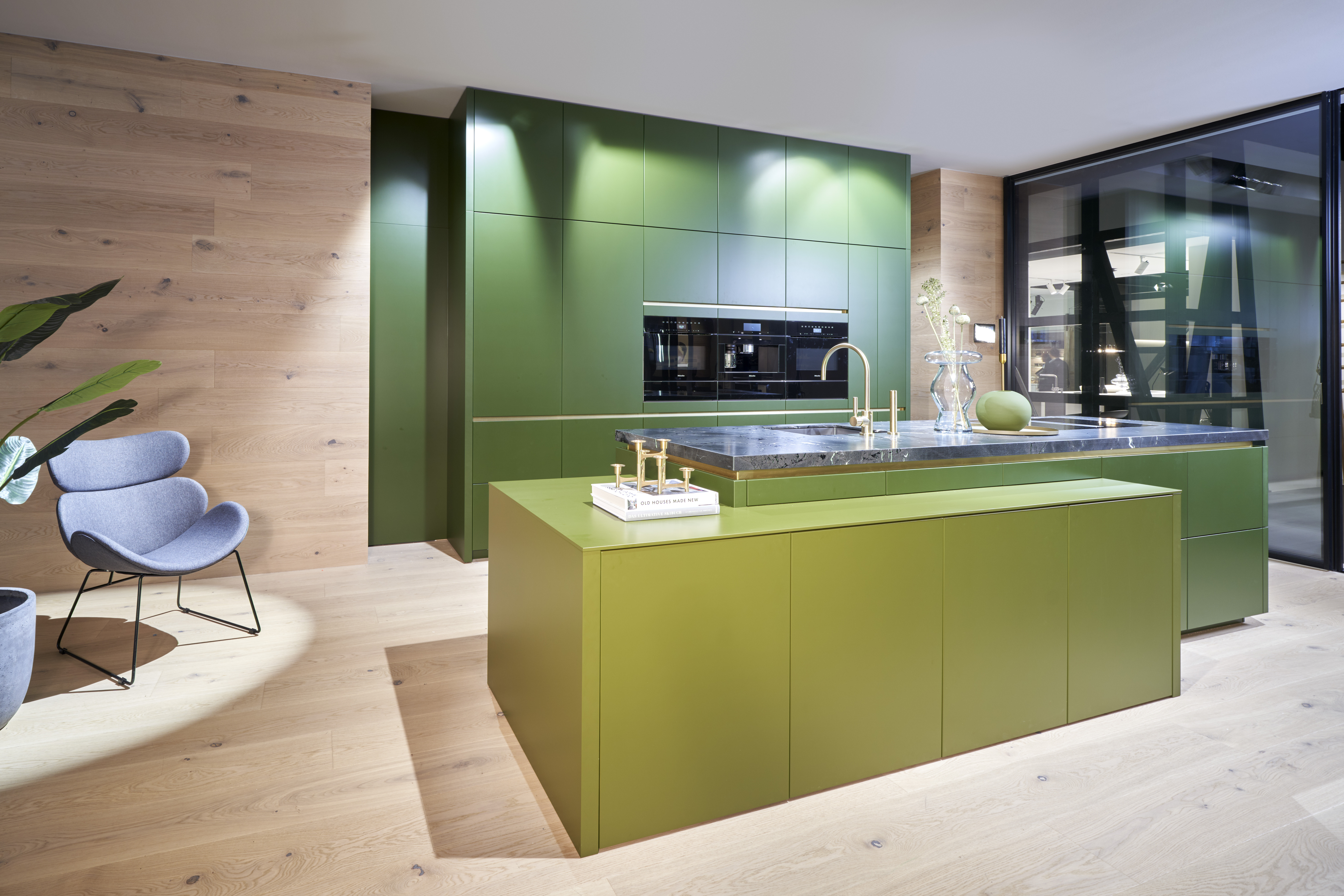 Moderne grüne Design-Küche von di Vinci Kitchen in Jestetten mit griffloser Kochinsel und integrierten Geräten.