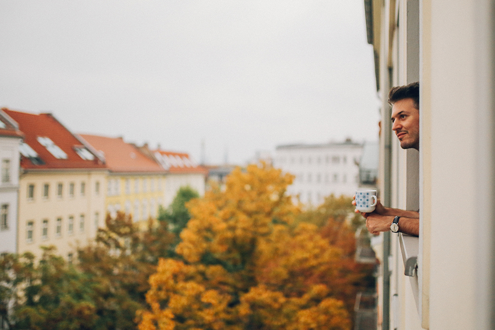 Mann in Berlin schaut aus dem Fenster
