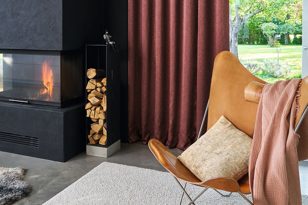 Wohnzimmer mit Teppich, Vorhang und Kamin als Beispiel für ein maßgeschneidertes Raumkonzept.