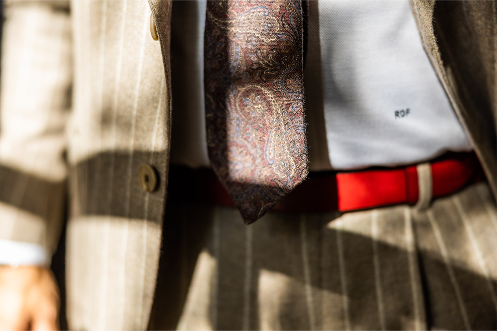 Maßanzug auf roten Gürtel und Shirt mit gemusterter Krawatte