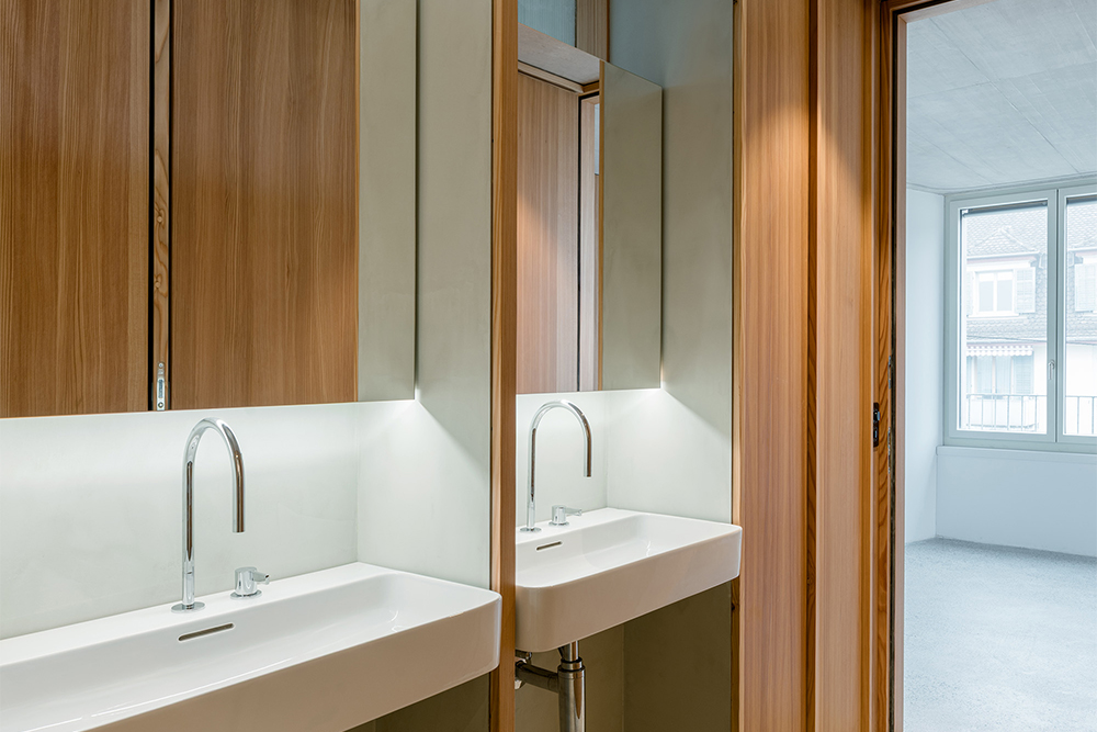 Modernes Badezimmer-Design mit Doppelwaschbecken und Echtholz-Verkleidung, realisiert durch K&uuml;bler AG Innenausbau und Schreinerei