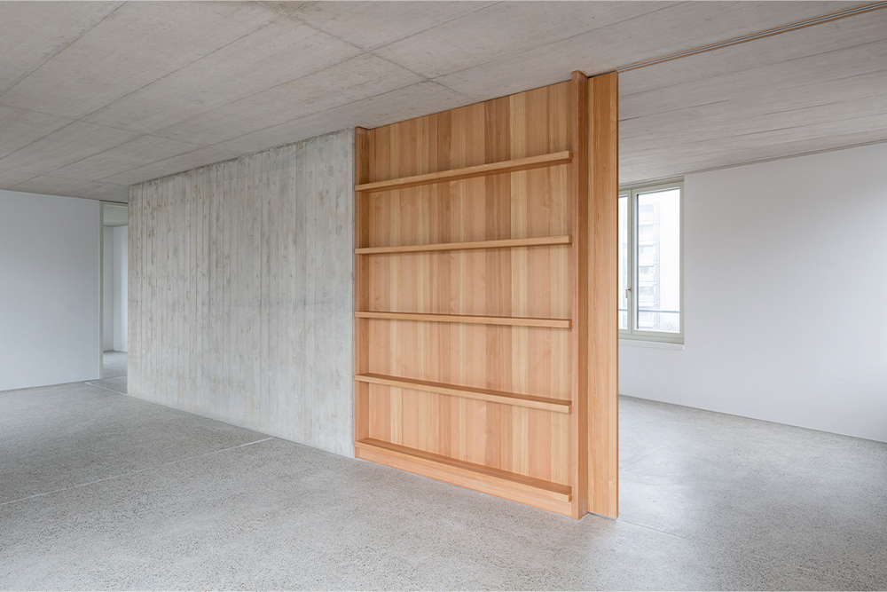 Ma&szlig;gefertigter Raumteiler aus Holz und Sichtbeton-Wand &ndash; hochwertiges Handwerk der K&uuml;bler AG Innenausbau.