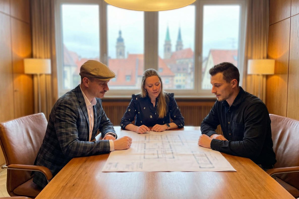 Mitarbeiter von MR Immo GmbH / Reidelbach Immobilien besprechen sich untereinander