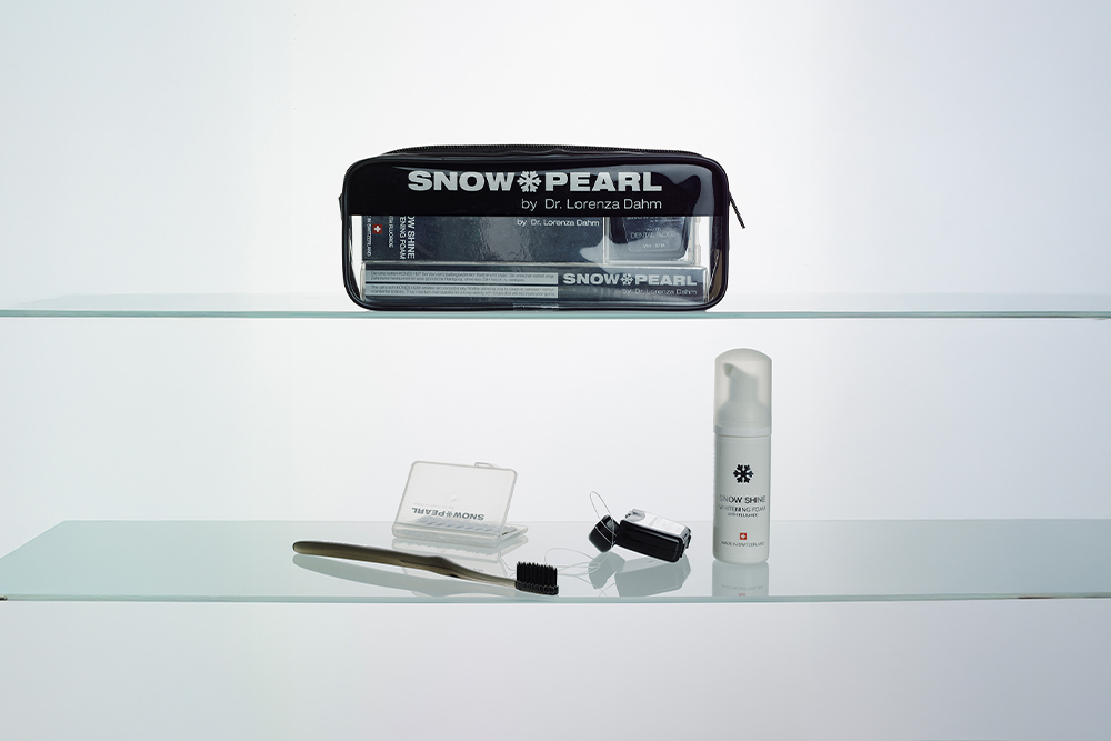 SNOW PEARL Mundpflegeprodukte mit schwarzem Travel Set auf Glasablagen
