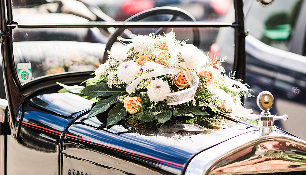 Stilpunkte: Zur Hochzeit im klassischen Oldtimer-Cabrio mit Blumenschmuck auf der Motorhaube