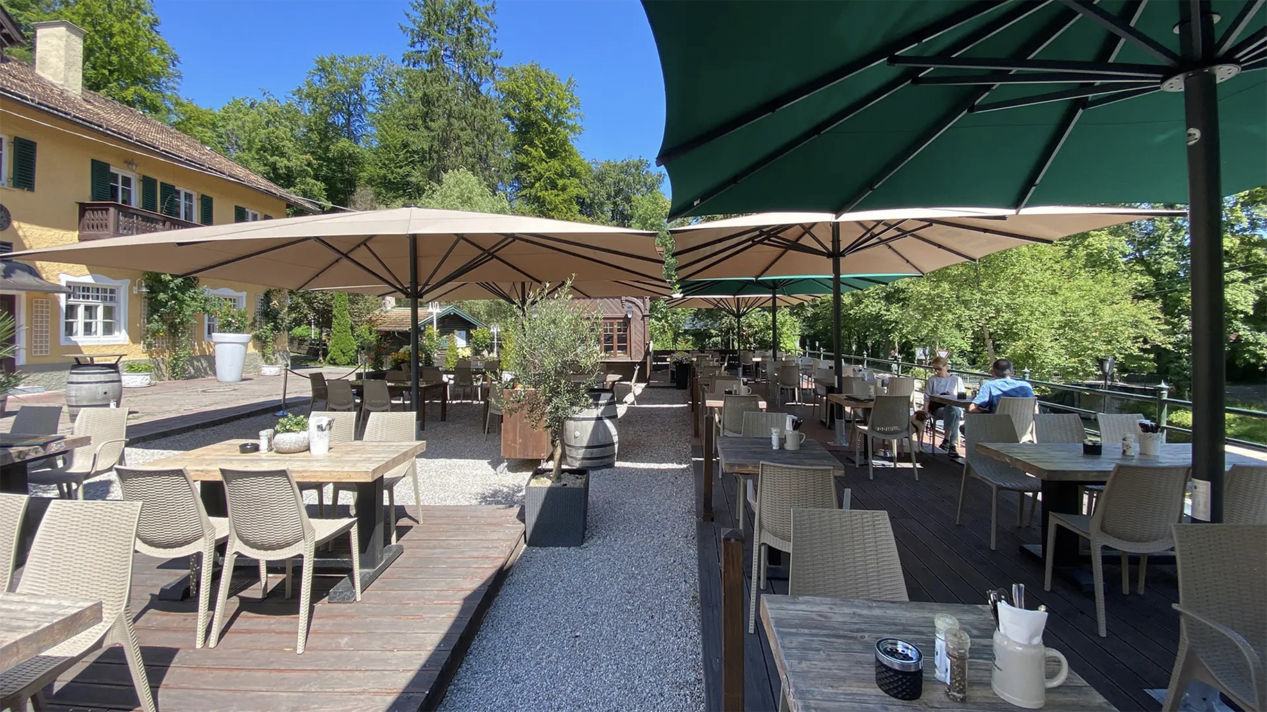 Außenbereich eines Biergartens mit Sitzmöglichkeiten & großen Schirmen