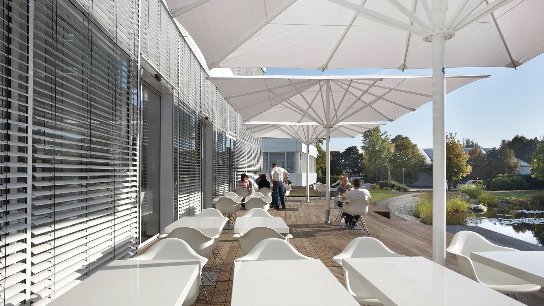 Terrasse mit Sitzmöglichkeiten und Großschirmen als Sonnenschutz